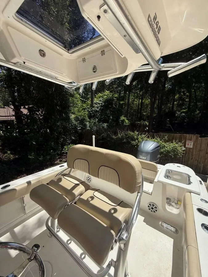 Slide: The Image of 2018 Sea Fox 248 Commander boat interior with seating and console, surrounded by trees. - 7