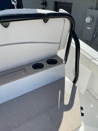 Slide: The Image of 2023 Sea Hunt Ultra 265 SE boat interior with cup holders and railing. - 13