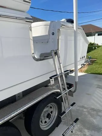 Slide: The Image of 2023 Sea Hunt Ultra 265 SE boat ladder on trailer in driveway. - 16