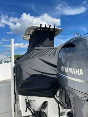 Slide: The Image of 2023 Sea Hunt Ultra 265 SE boat with Yamaha engine, covered and docked under blue sky. - 17