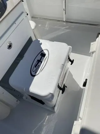 Slide: The Image of 2023 Sea Hunt Ultra 265 SE boat interior with storage compartment and cooler. - 19