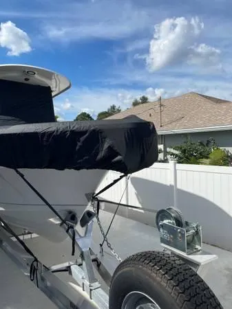 Slide: The Image of 2023 Sea Hunt Ultra 265 SE boat on trailer, covered, with blue sky background. - 2