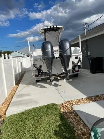 Slide: The Image of 2023 Sea Hunt Ultra 265 SE boat with dual outboard motors parked in driveway. - 4