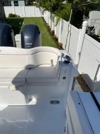 Slide: The Image of 2023 Sea Hunt Ultra 265 SE boat with dual 150 engines, white seating, and outdoor setting. - 9