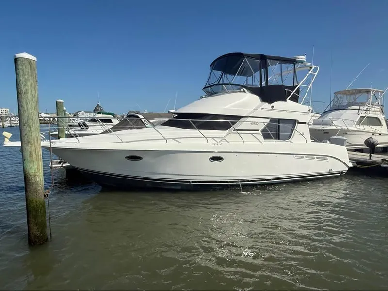 The Image of 2001 Silverton 351 Sedan Cruiser docked in a marina under clear blue skies. - 1