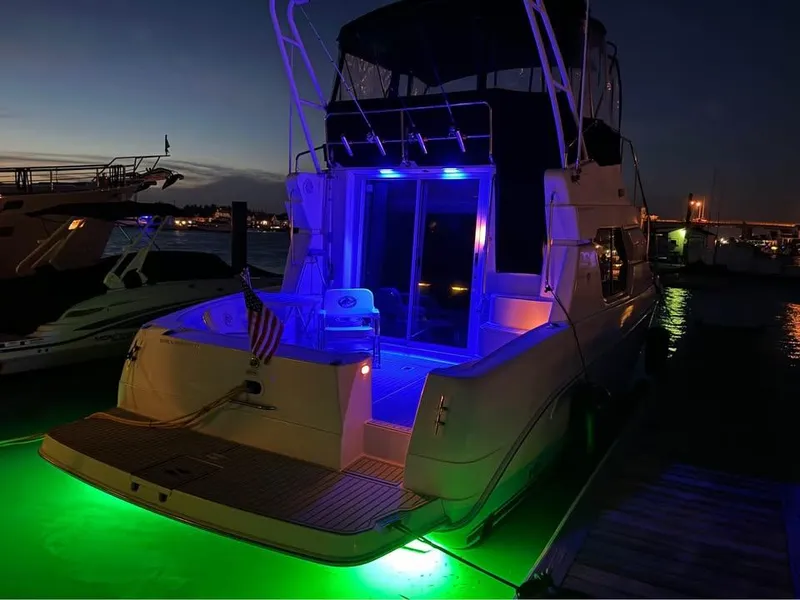 Slide: The Image of 2001 Silverton 351 Sedan Cruiser with vibrant blue and green lights at night dock. - 11