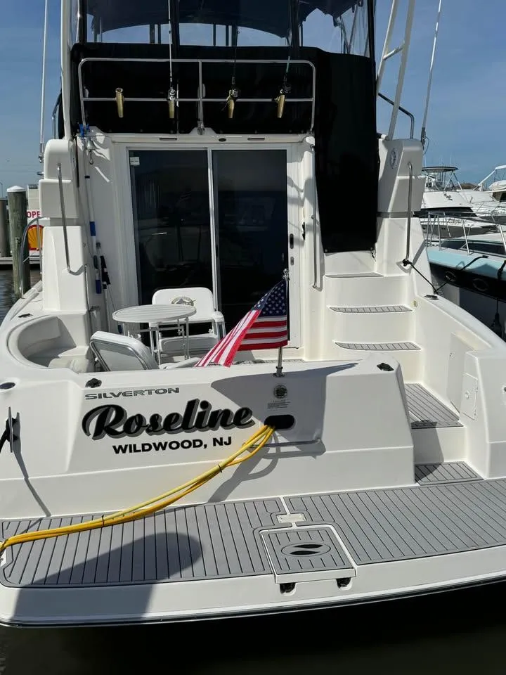 Slide: The Image of 2001 Silverton 351 Sedan Cruiser docked, featuring "Roseline" name and American flag. - 12