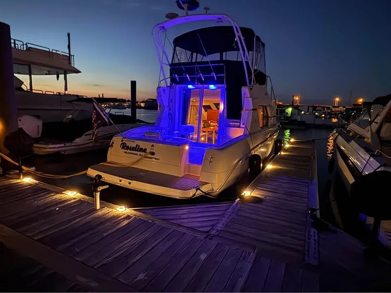 Slide: The Image of 2001 Silverton 351 Sedan Cruiser docked at night with blue interior lights. - 16