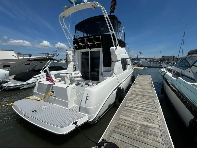 Slide: The Image of 2001 Silverton 351 Sedan Cruiser docked at marina under clear blue sky. - 5
