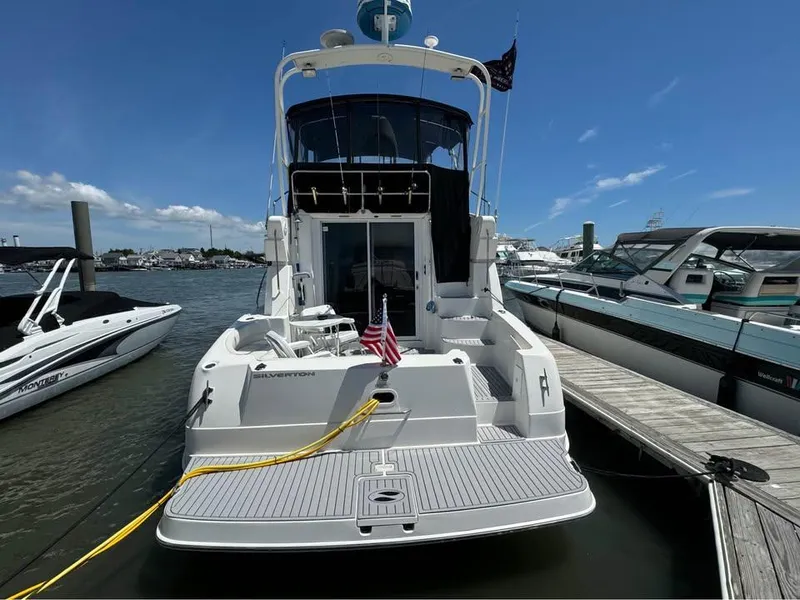 Slide: The Image of 2001 Silverton 351 Sedan Cruiser docked at marina under clear blue sky. - 6