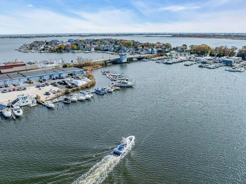 Slide: The Image of Aerial view of a 2023 Front Runner 39 Center Console boat navigating a marina. - 10
