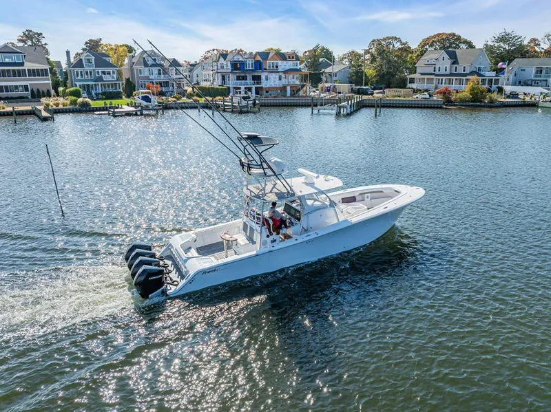 Slide: The Image of 2023 Front Runner 39 Center Console boat cruising on a scenic waterfront. - 12