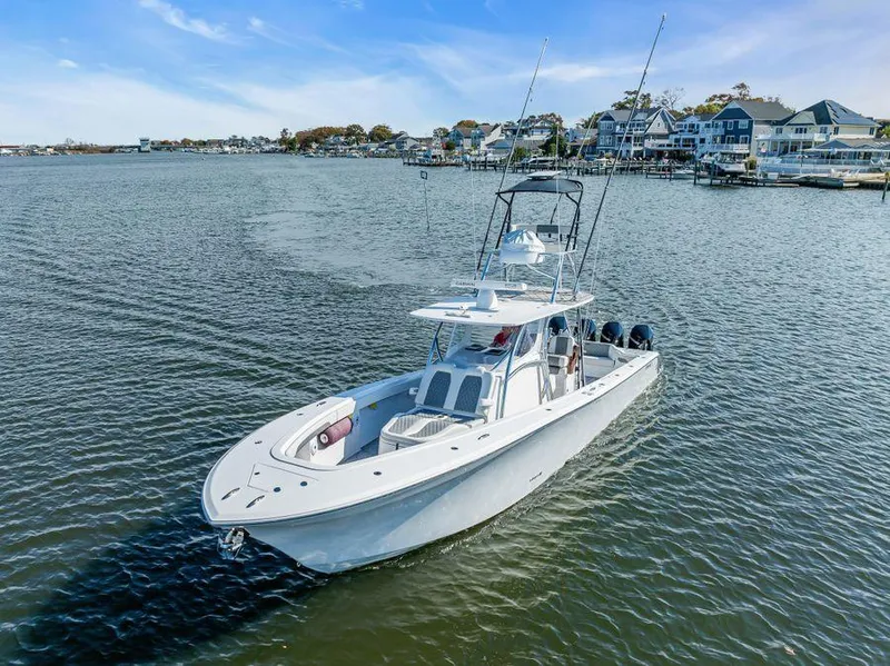 Slide: The Image of 2023 Front Runner 39 Center Console boat on calm water near coastal homes. - 13