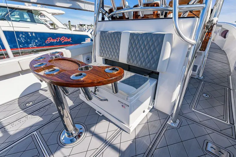 Slide: The Image of 2023 Front Runner 39 Center Console boat interior with seating and wooden table. - 23