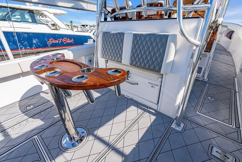 Slide: The Image of 2023 Front Runner 39 Center Console boat interior with elegant wood table and cushioned seating. - 24