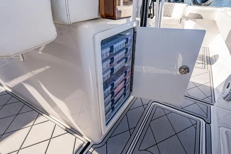 Slide: The Image of 2023 Front Runner 39 Center Console with open storage compartment and organized tackle boxes. - 29