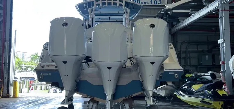 Slide: The Image of 2018 Cobia 344 Center Console boat with triple outboard engines in a storage facility. - 10