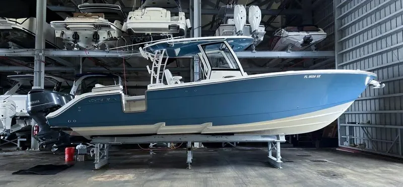 Slide: The Image of 2018 Cobia 344 Center Console boat in storage, blue hull, indoor facility. - 3