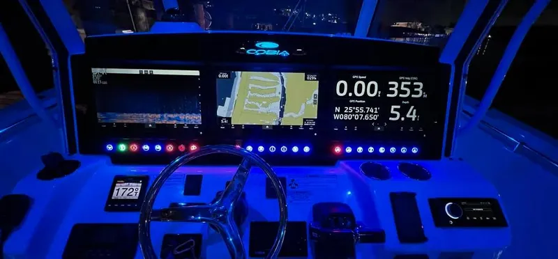 Slide: The Image of 2018 Cobia 344 Center Console dashboard with illuminated navigation screens at night. - 4
