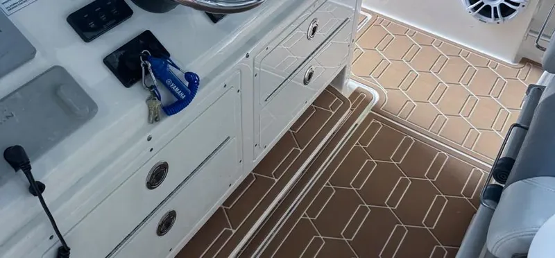 Slide: The Image of 2018 Cobia 344 Center Console boat interior with steering wheel and patterned flooring. - 5