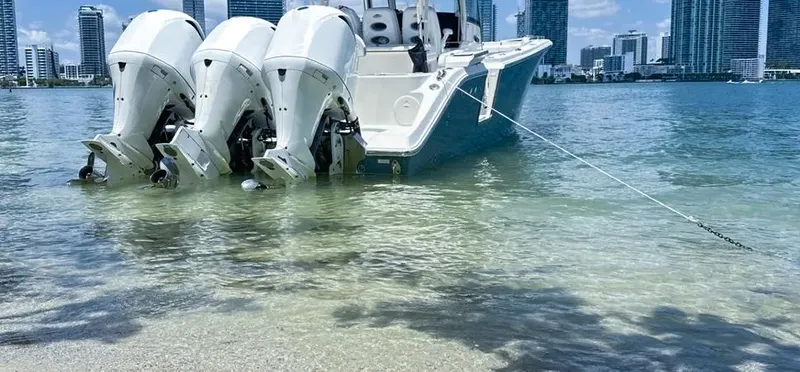 Slide: The Image of 2018 Cobia 344 Center Console boat anchored near city skyline. - 9
