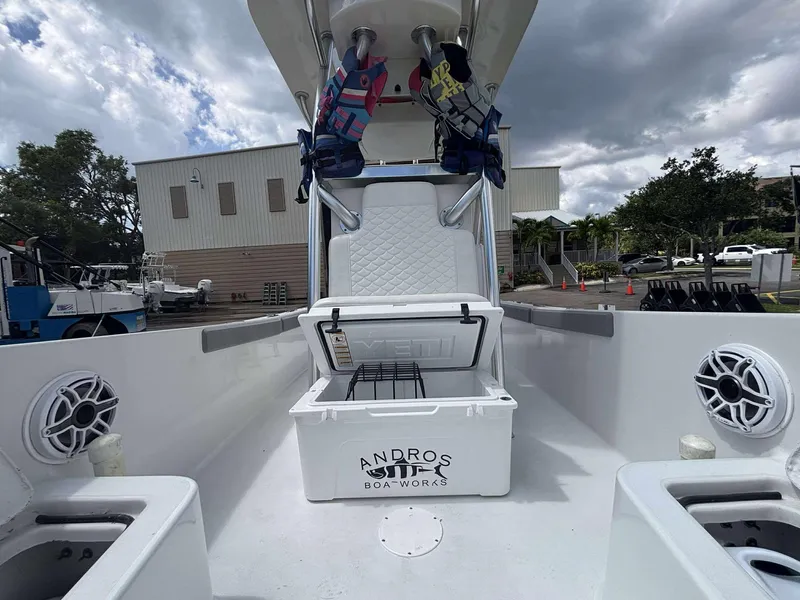 Slide: The Image of 2007 Andros Tarpon 26 boat interior with open cooler and life jackets under cloudy sky. - 16