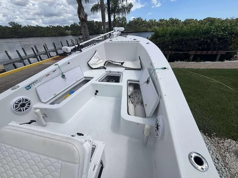 Slide: The Image of 2007 Andros Tarpon 26 boat interior with storage compartments and seating, docked by a scenic river. - 15