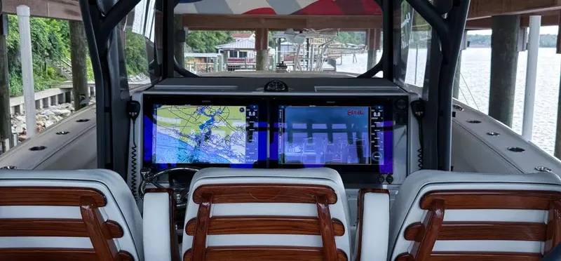 Slide: The Image of Helm of 2019 Freeman 42 LR boat with advanced navigation screens and wooden seats. - 17