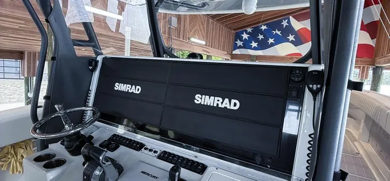 Slide: The Image of Control panel of a 2019 Freeman 42 LR boat with Simrad displays and American flag decor. - 25