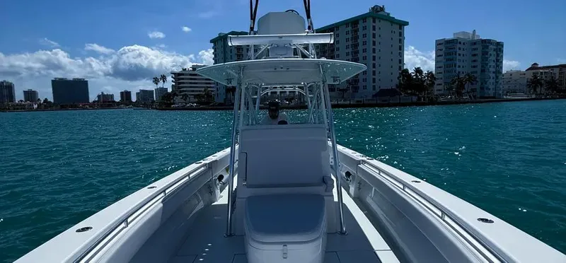 Slide: The Image of 2022 Contender 39 ST boat cruising on clear blue water near city skyline. - 15