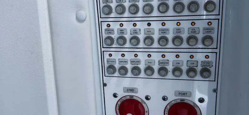 Slide: The Image of Control panel of a 2022 Contender 39 ST boat with various switches and dials. - 28