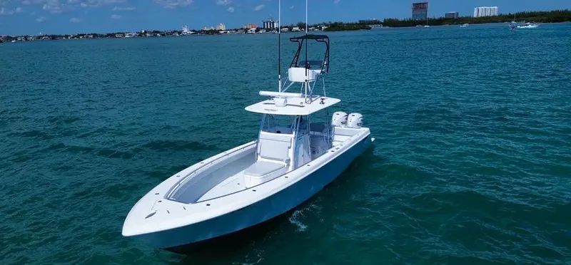 Slide: The Image of 2022 Contender 39 ST boat on open water, clear sky, distant shoreline. - 4
