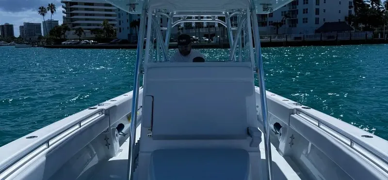 Slide: The Image of 2022 Contender 39 ST boat cruising on clear blue water near cityscape. - 8