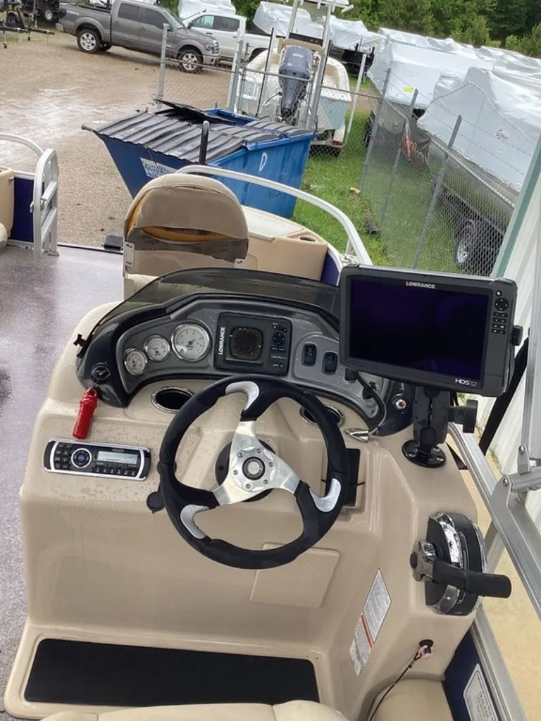 Slide: The Image of Interior view of a 2016 Sun Tracker 22DLX boat cockpit with steering and instruments. - 22