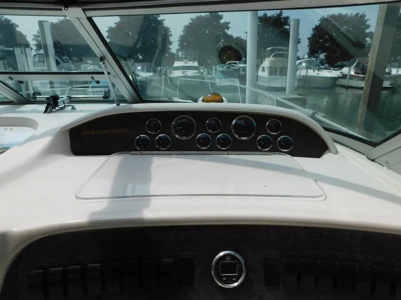 Slide: The Image of 1997 Sea Ray 330 Sundancer dashboard with gauges and marina view. - 26