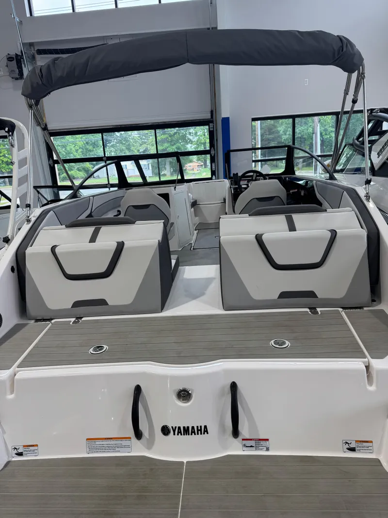Slide: The Image of 2025 Yamaha Boats SX220 interior with seating and canopy in showroom. - 2