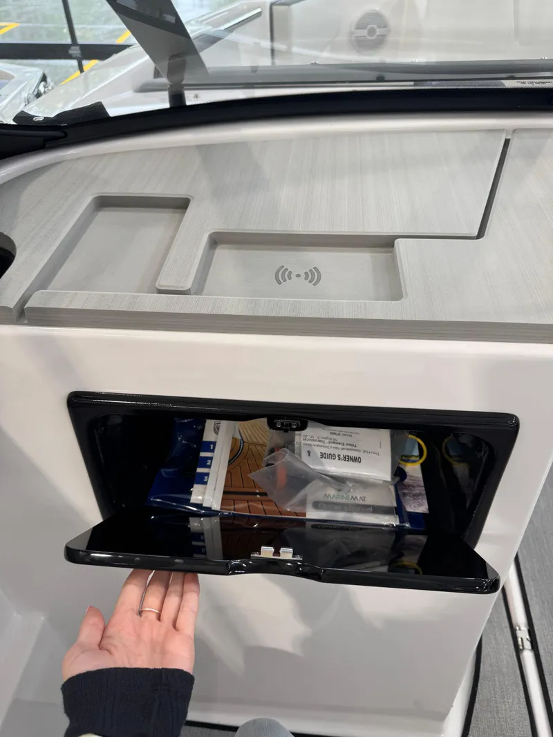 Slide: The Image of 2025 Yamaha Boats SX220 dashboard with storage compartment and wireless charging pad. - 7