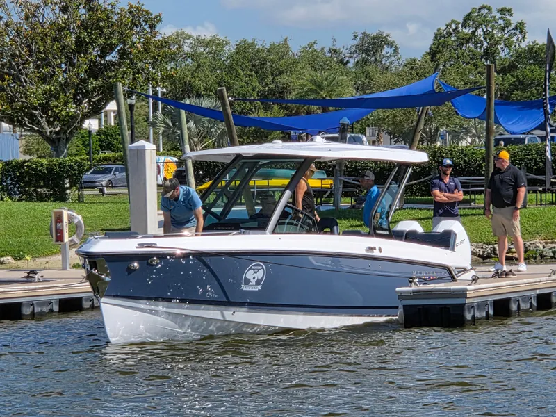 Slide: The Image of 2025 Monterey Elite 30 OB boat docked with people nearby on a sunny day. - 0