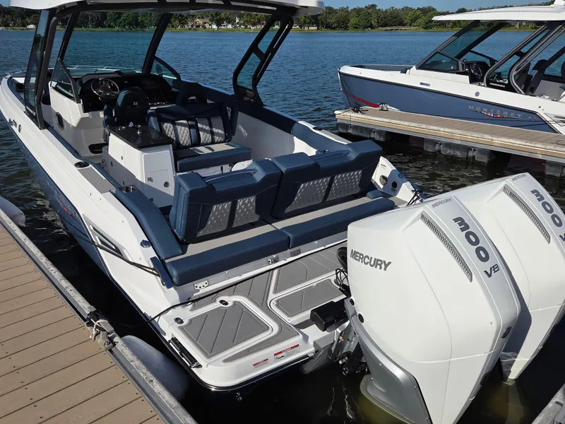 Slide: The Image of 2025 Monterey Elite 30 OB boat with dual Mercury 300 V8 engines docked on a lake. - 1