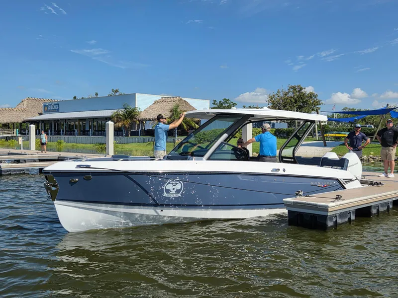 Slide: The Image of 2025 Monterey Elite 30 OB boat docked with people onboard, clear blue sky background. - 5