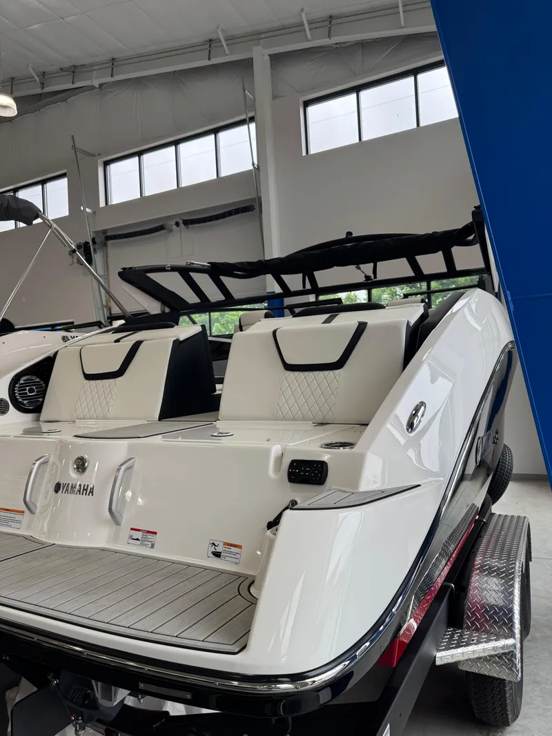 Slide: The Image of 2025 Yamaha Boats 222SD in showroom, featuring sleek design and modern seating. - 2