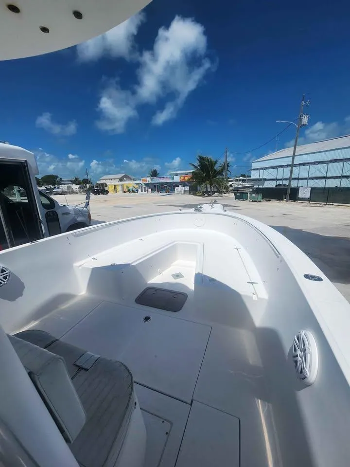 Slide: The Image of 2006 Stamas 290 Tarpon boat, docked under clear blue sky, showcasing spacious deck. - 6