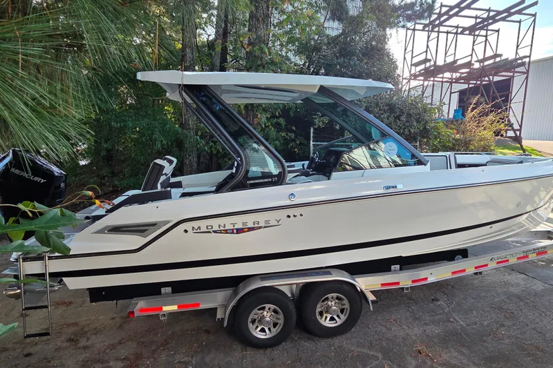 Slide: The Image of 2026 Monterey Elite 27 OB boat on trailer, surrounded by trees and outdoor setting. - 12