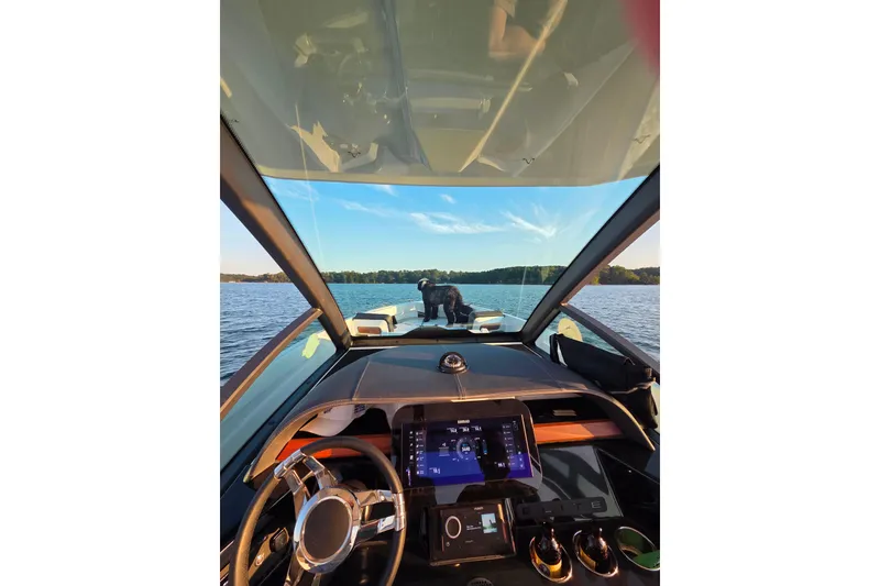 Slide: The Image of Interior view of 2026 Monterey Elite 27 OB boat on a serene lake. - 16