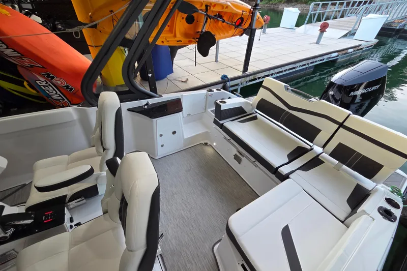 Slide: The Image of 2026 Monterey Elite 27 OB boat interior with seating, docked by the water. - 22