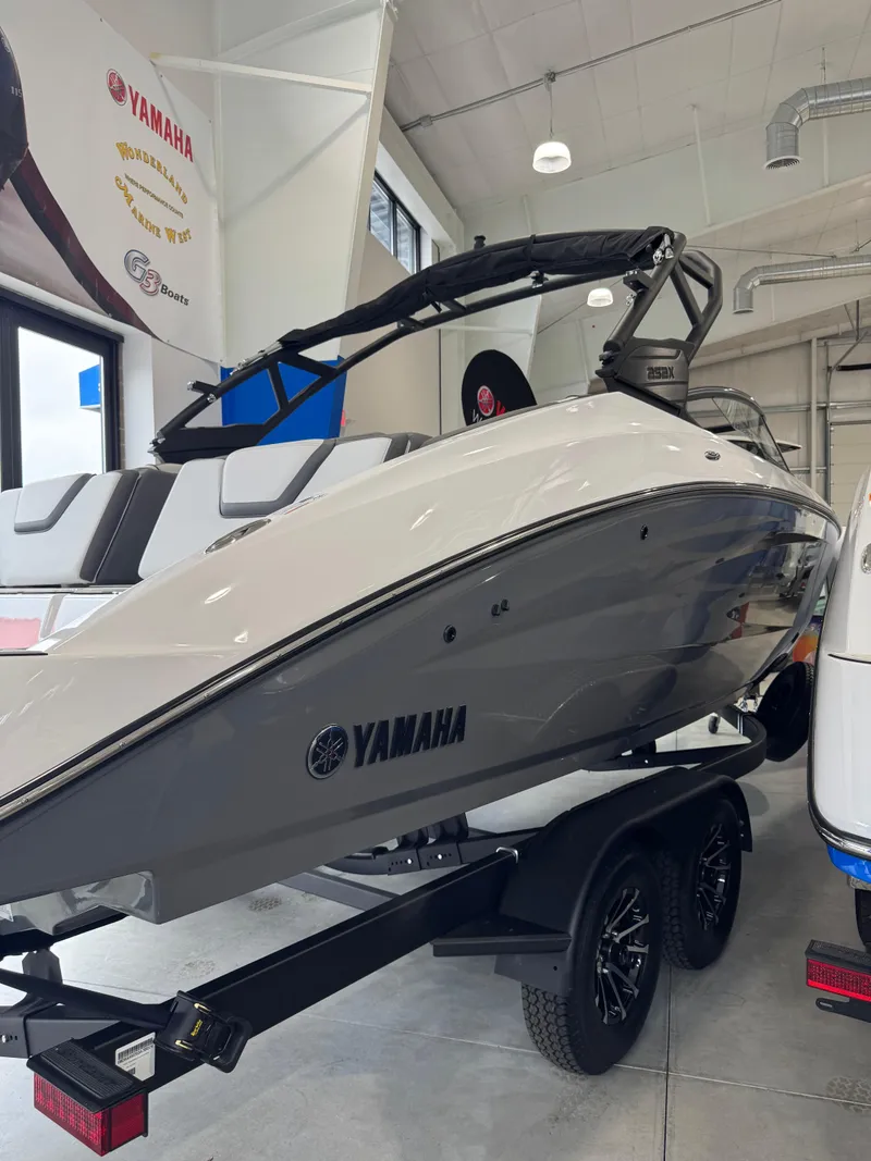 The Image of 2025 Yamaha Boats 252XE displayed indoors on a trailer. - 0