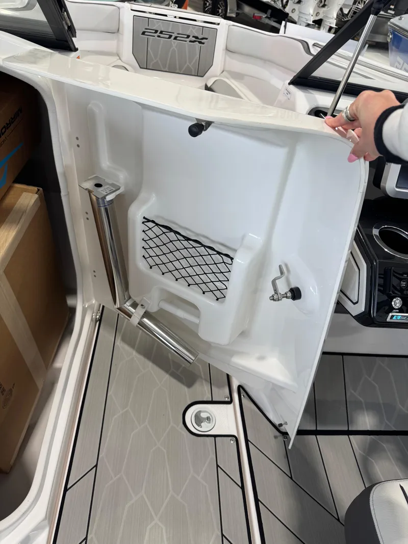 Slide: The Image of 2025 Yamaha Boats 252XE interior detail with storage compartment and sleek design. - 12