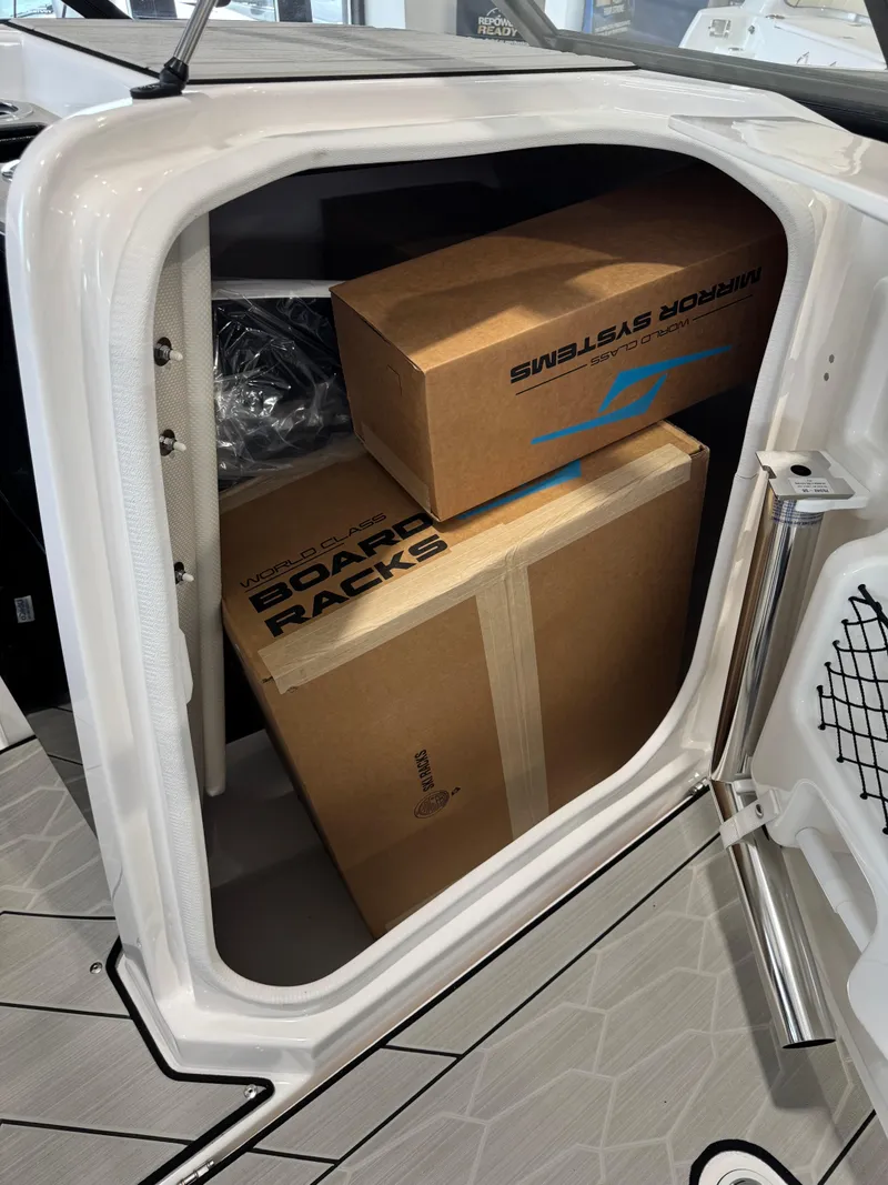 Slide: The Image of Storage compartment in 2025 Yamaha Boats 252XE with board racks and mirror systems boxes. - 13