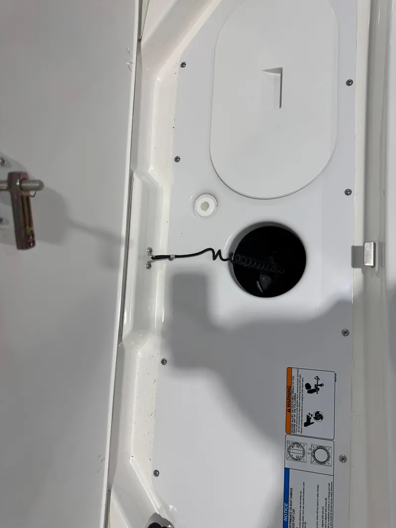 Slide: The Image of 2025 Yamaha Boats 195S interior compartment with latch and safety instructions. - 9