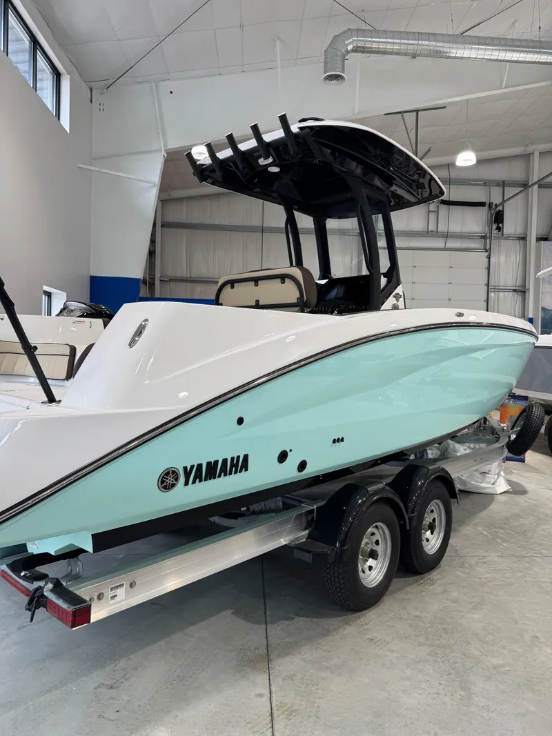 The Image of 2025 Yamaha Boats 255 FSH Sport E in showroom, sleek design on trailer. - 0